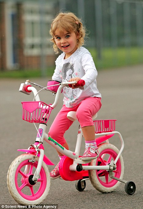 Encantada, Sophie mostra como ela é capaz de andar de bicicleta com mais facilidade agora.