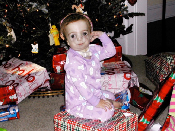 Clara, 1 ano e 4 meses, sentada em frente a árvore de natal (Photo: AP/Martha Irvine)