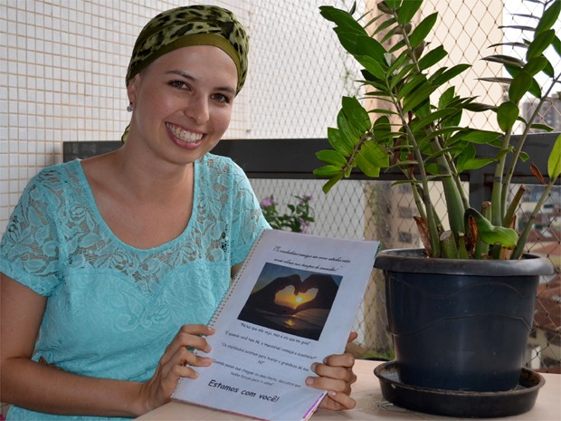 Lívia exibe livro de mensagens que ganhou dos amigos que participam de um grupo de jovens (Foto: Fernanda Testa/G1)